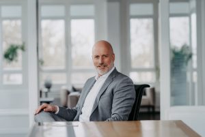 Das Bild zeigt Dr. Matthias Hallweger, sitzend am Schreibtisch